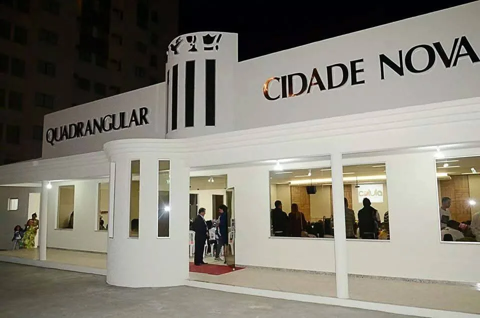 Fachada da Igreja Quadrangular Cidade Nova à noite, com a igreja reunida no interior